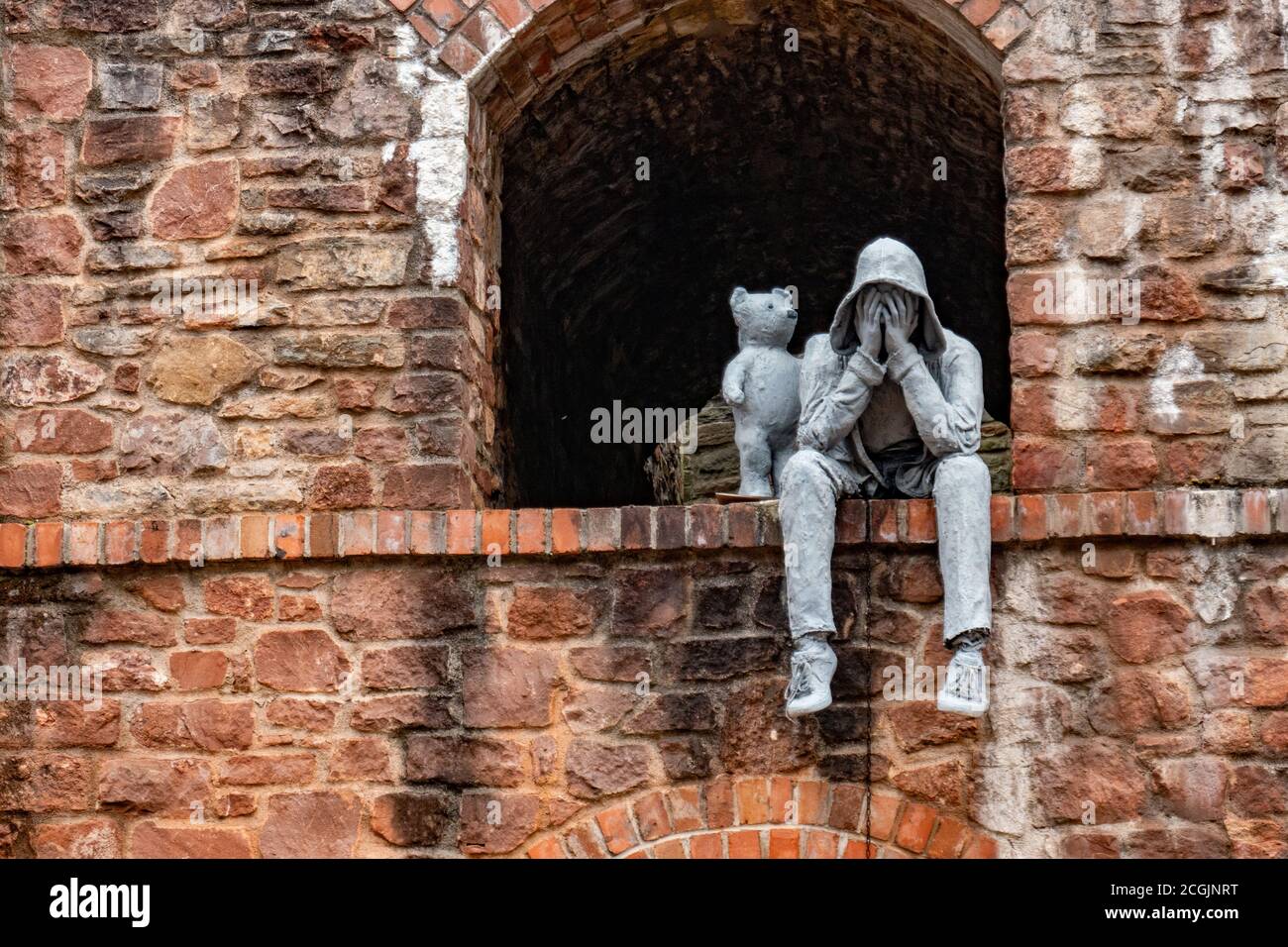 Eine Statue, die einen weinenden Mann zeigt, der von einem kleinen Bären getröstet wird, Bristol, Großbritannien Stockfoto