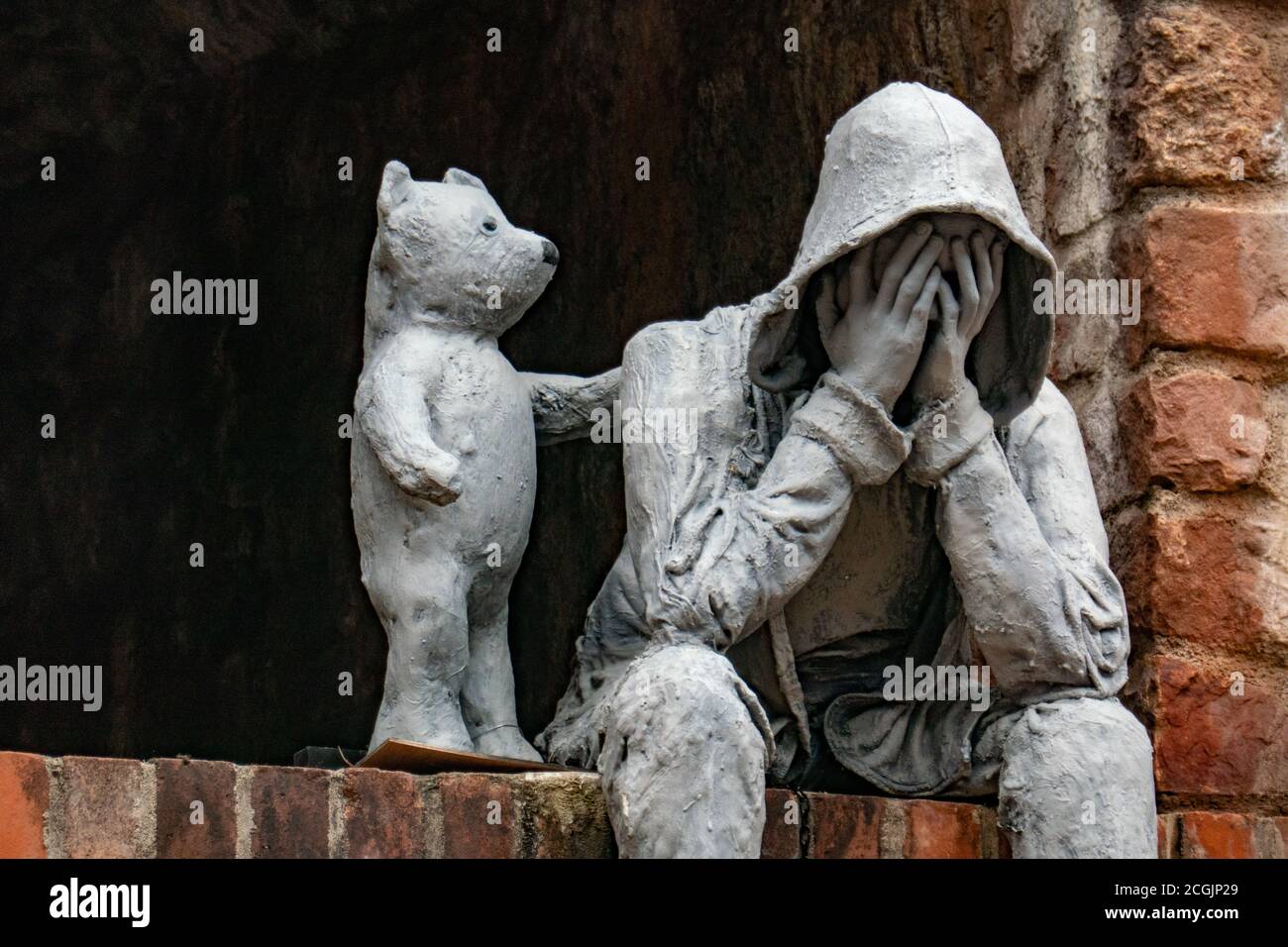 Eine Statue, die einen weinenden Mann zeigt, der von einem kleinen Bären getröstet wird, Bristol, Großbritannien Stockfoto