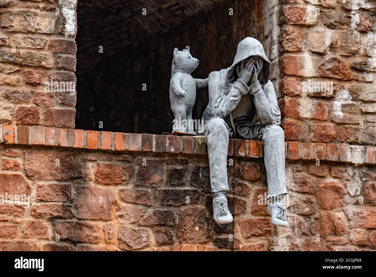 Eine Statue, die einen weinenden Mann zeigt, der von einem kleinen Bären getröstet wird, Bristol, Großbritannien Stockfoto