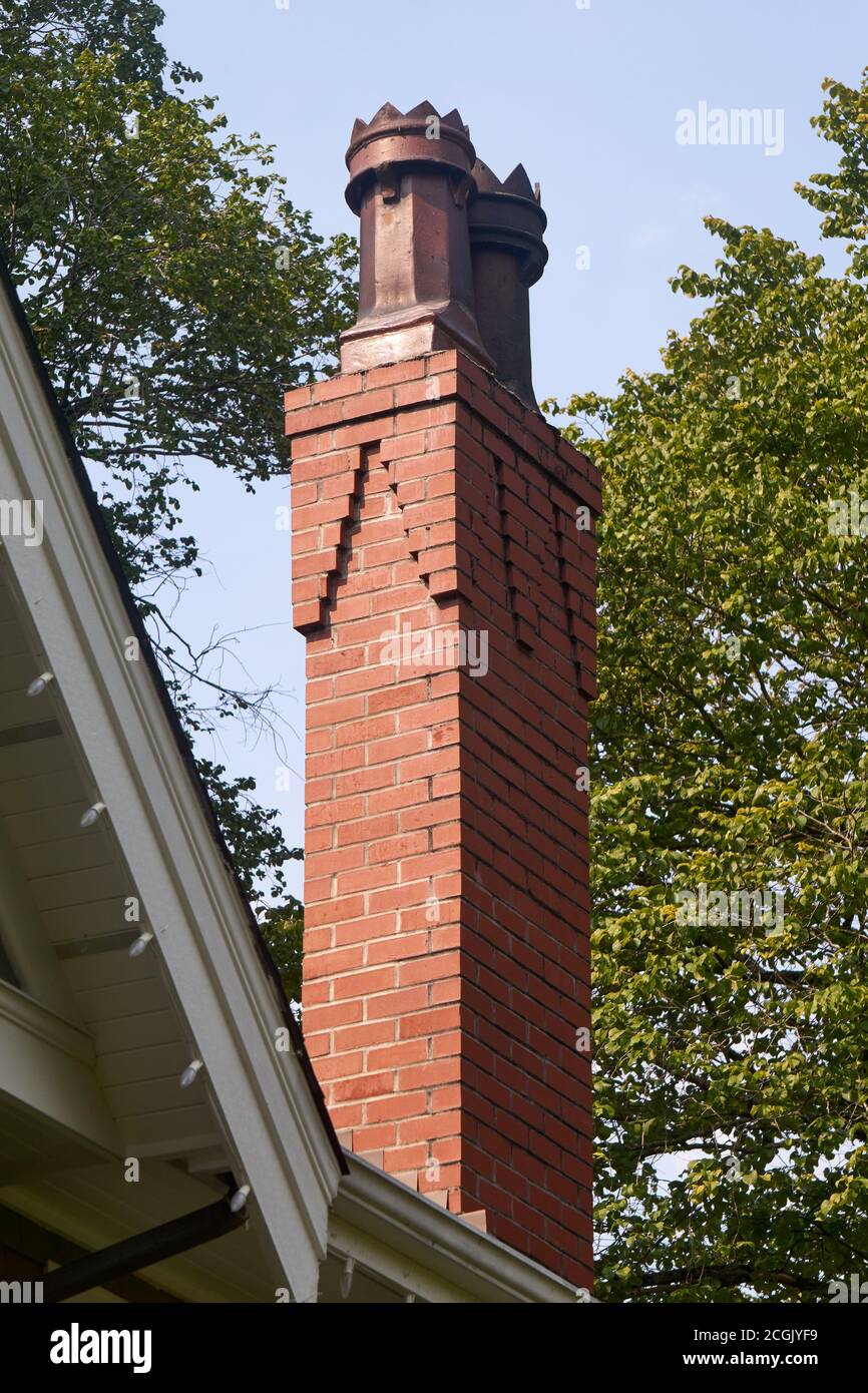 Dekorativer Kamintopf oder Kamintöpfe auf dem roten Ziegel Kamin eines Hauses Stockfoto