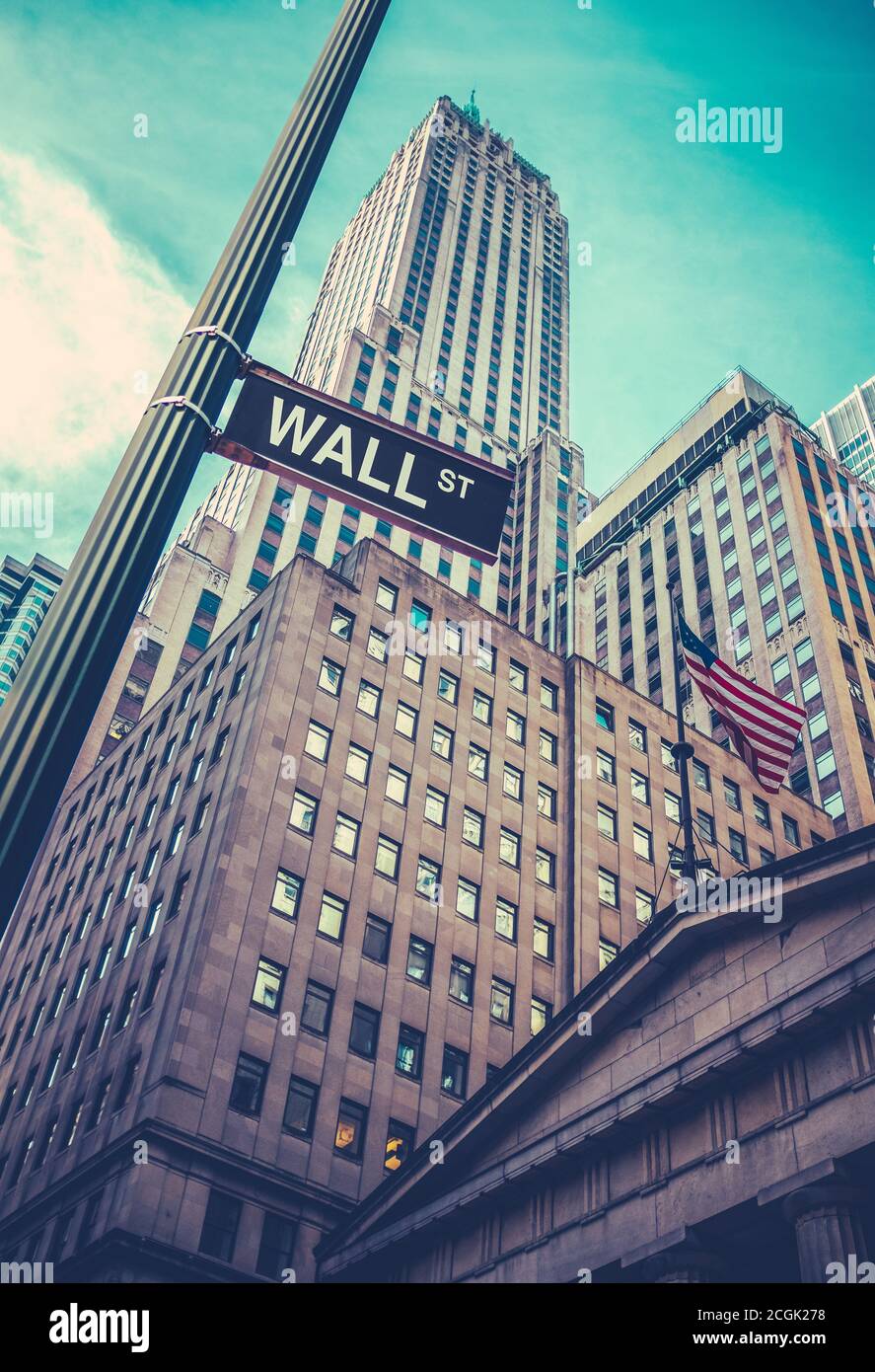 Ein Schild für die Wall Street in Lower Manhattan, New York, mit Wolkenkratzern dahinter Stockfoto