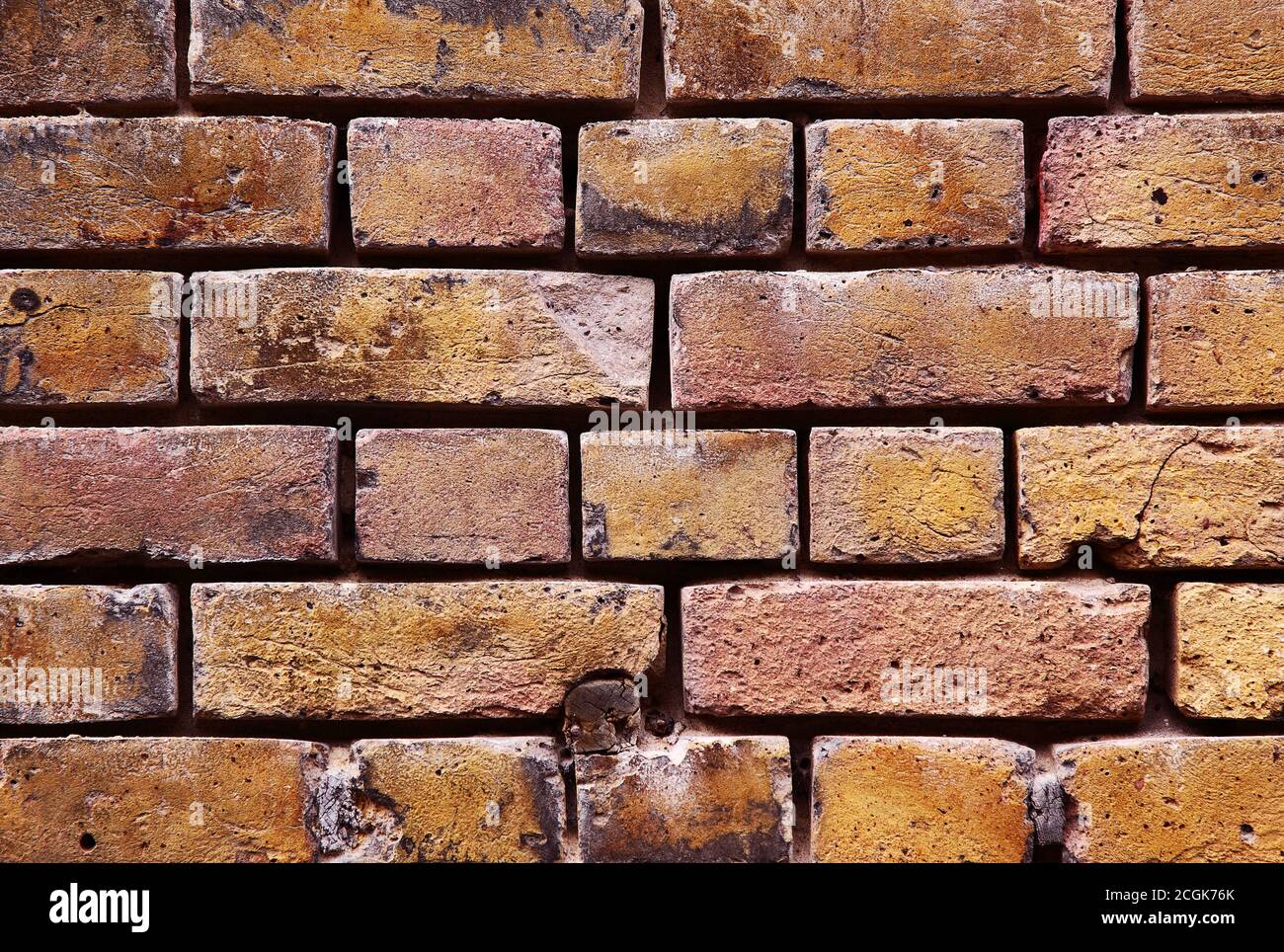 Viktorianische gelbe Mauerwerk Wand strukturierten Hintergrund mit Mörtel erodiert weg Zwischen Ziegeln Stockfoto