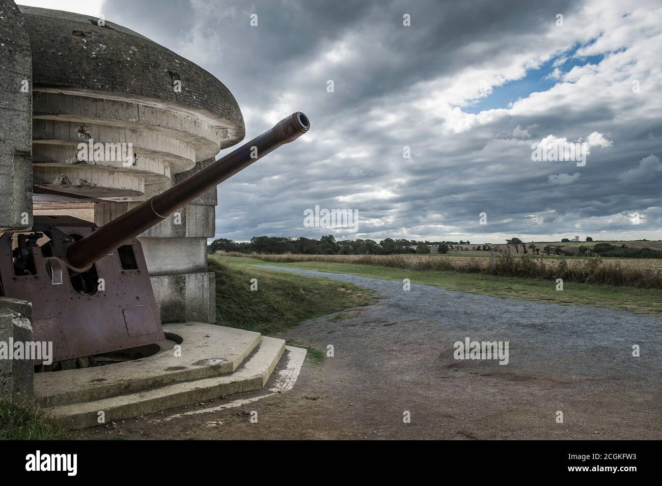 Eine große deutsche Kanone in der Longues-sur-Mer Batterie mit Blick auf Gold Beach, in der Nähe von Arromanches, Normandie, Frankreich Stockfoto