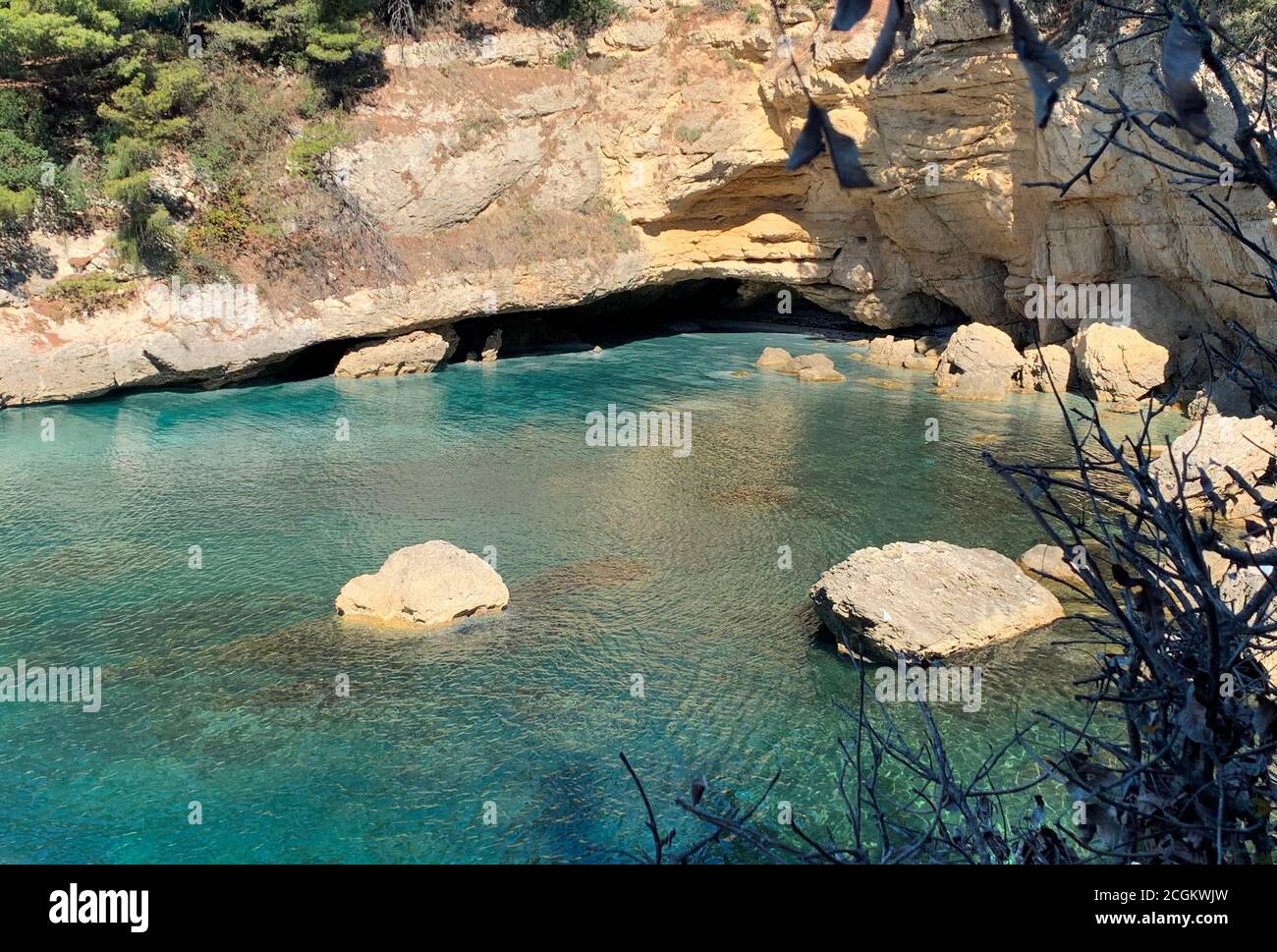 Malerischer Felsenstrand an der Adriaküste von Montenegro. Malerische Felsen, Meereshöhle, klares blaues Mittelmeer. Ruhiges türkisfarbenes Wasser. Sommerurlaub. Stockfoto