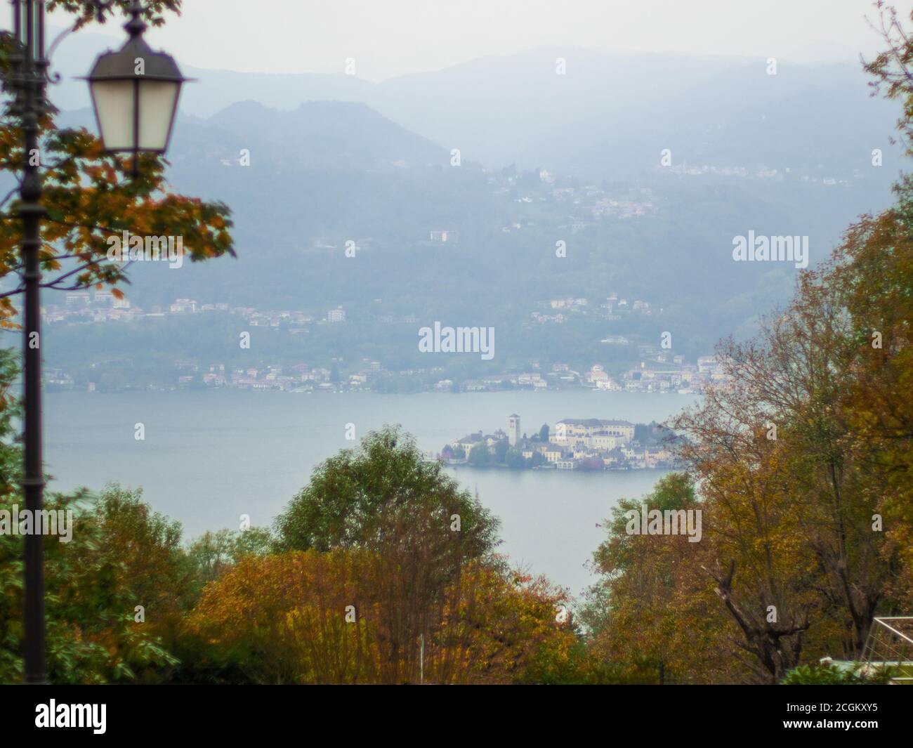 Herbstlicher Rahmen aus vergilbten Blättern am Ortasee, umhüllt vom Morgennebel.Piemont, Norditalien Stockfoto