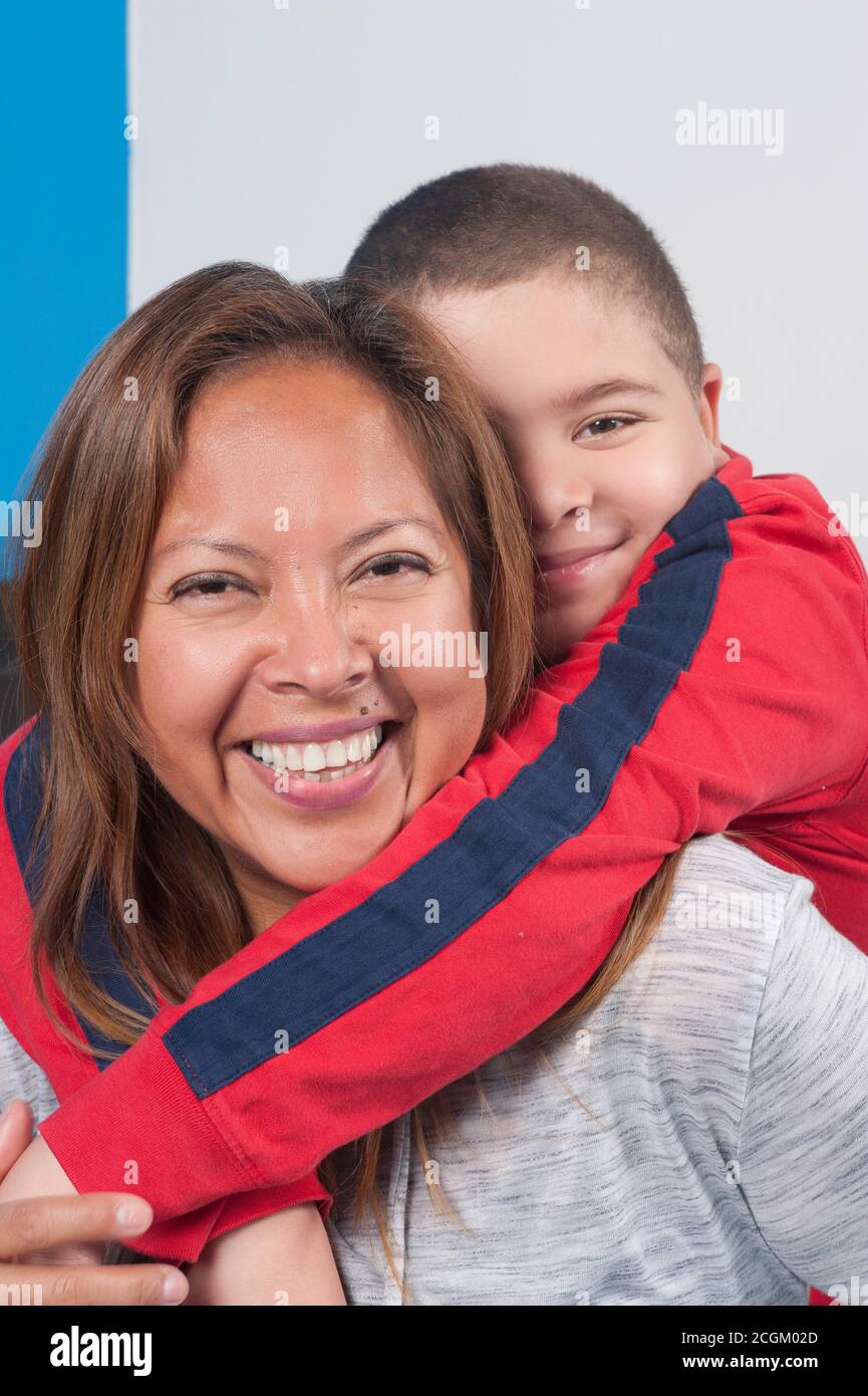 6 Jahre alter Junge umarmt seine Großmutter um ihren Hals, Porträt Nahaufnahme vertikal Stockfoto