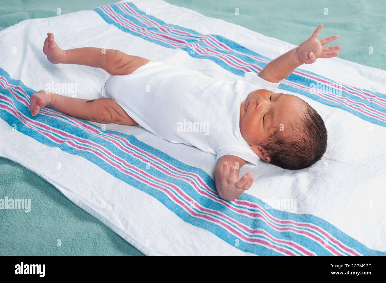 Neugeborener Junge, 1 Woche alt Reflex Moro (Schrecke), volle Länge auf dem Rücken, liegend auf der Empfangsdecke Stockfoto