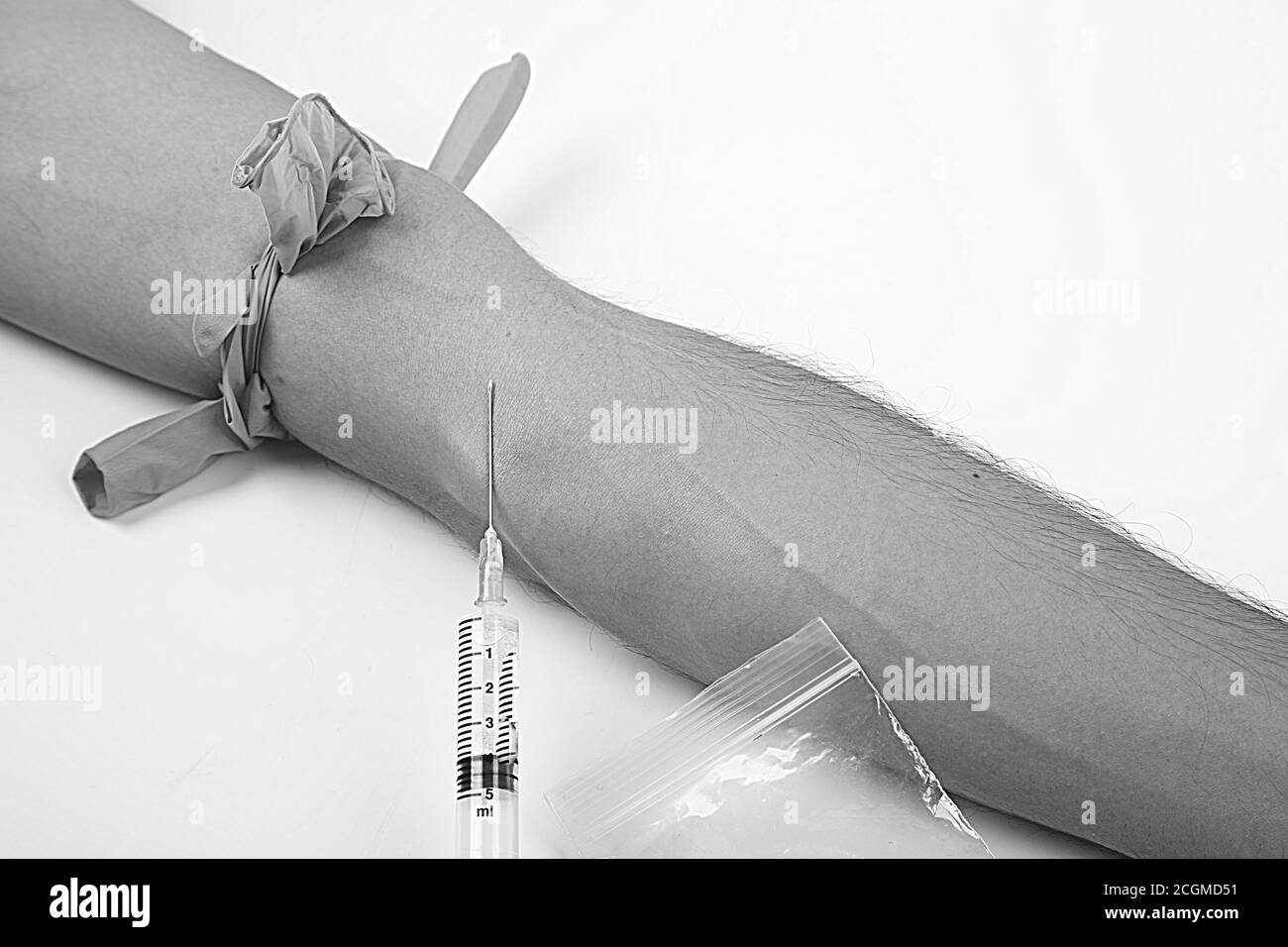 Drogenabhängigkeit, Mann mit Drogen in Spritze, weiß und isoliert Hintergrund, schwarz-weiß Foto Stockfoto