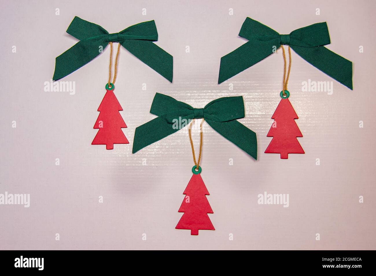 Ornament auf die Weihnachtsgeschenke in Form einer roten Weihnachtstanne mit einer grünen Schleife auf der Oberseite zu platzieren. Stockfoto