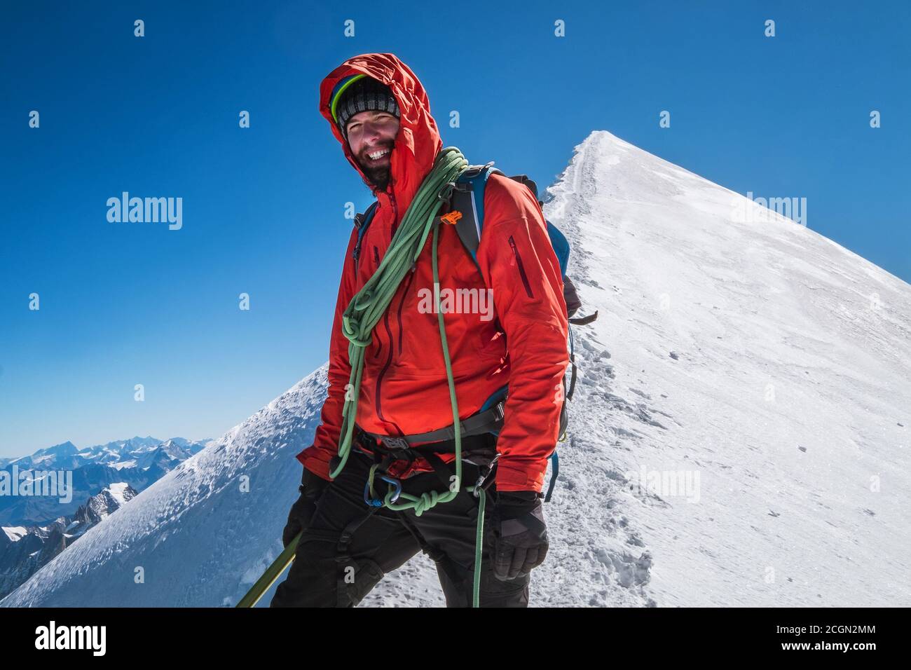 Letzte Schritte vor dem Mont Blanc (Monte Bianco) Gipfel 4808 m Seilschaft glücklich lächelnden Mann in Klettergeschirr gekleidet rote Bergsteigen Kleidung auf der Stockfoto
