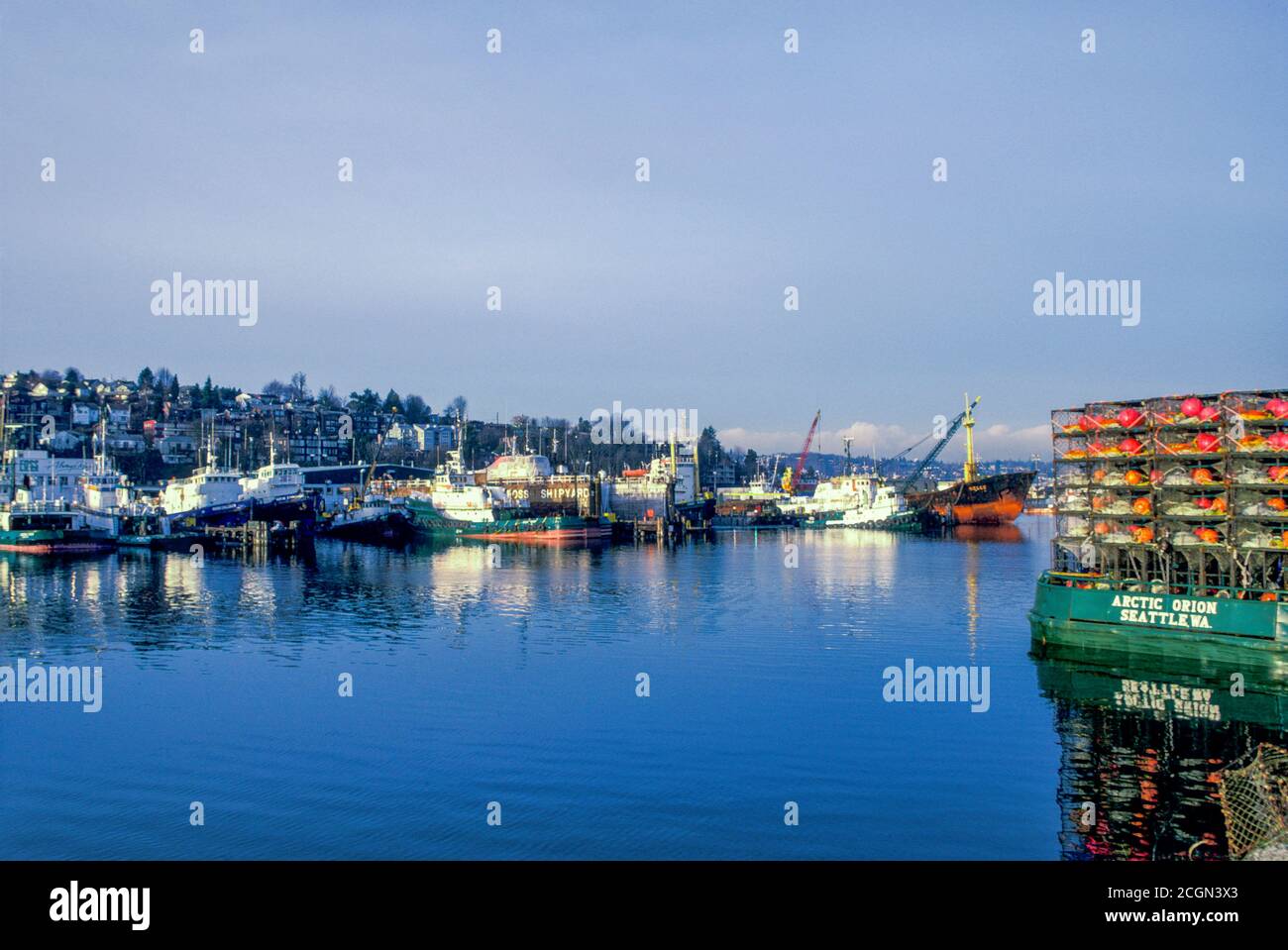 Crab Töpfe gestapelt am Heck von kommerziellen Krabbenboot, mit kommerziellen Fischerboote in der Ferne, Lake Washington Ship Canal, Seattle, Washington USA Stockfoto