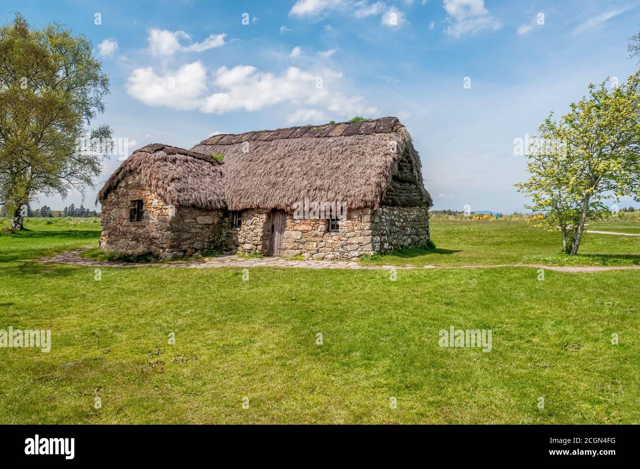 Schottisches Croft House mit Reetdach, errichtet als Beispielausstellung in einem öffentlichen Park in der Nähe von Lock Ness, Schottland. Stockfoto