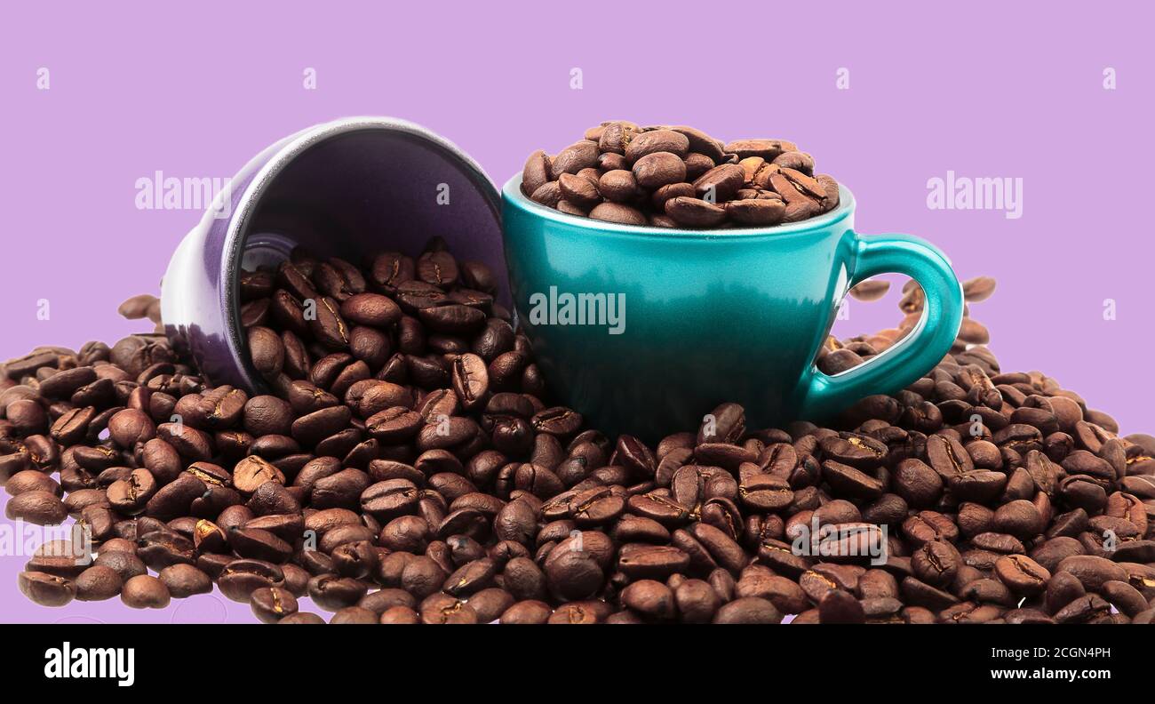 Tassen Kaffee mit Bohnen in und verschüttet herum mit Hintergrund in Pastelltönen Stockfoto