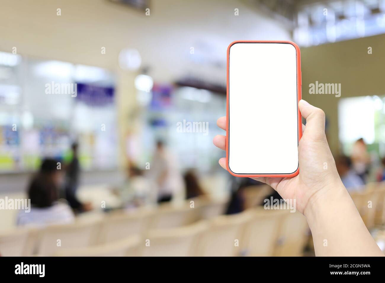 Hand eines Mannes hält Smartphone-Gerät im Krankenhaus verwischen Hintergrund und haben weiße Kopie Platz auf dem Bildschirm. Stockfoto