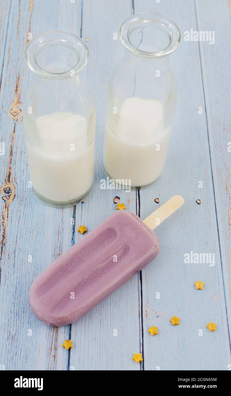 Traube Popsicle Whit Milch auf blauem Hintergrund rustikal Stockfoto
