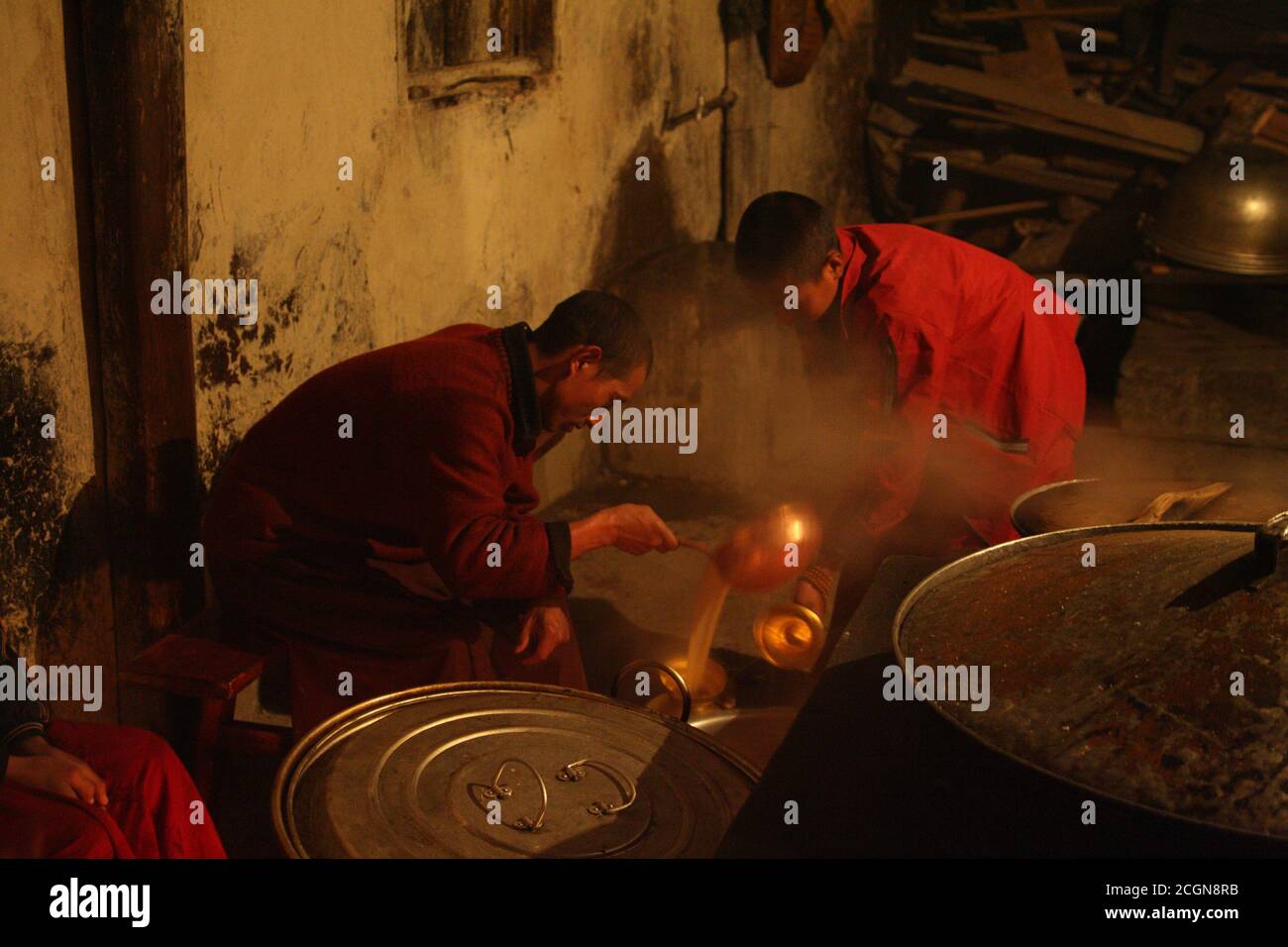 Koch und Lehrling Mönche Herstellung Yak Butter Tee, im Muli Kloster, Wachang Stadt, Muli, West Sichuan, China 18. Dezember 2006 Stockfoto