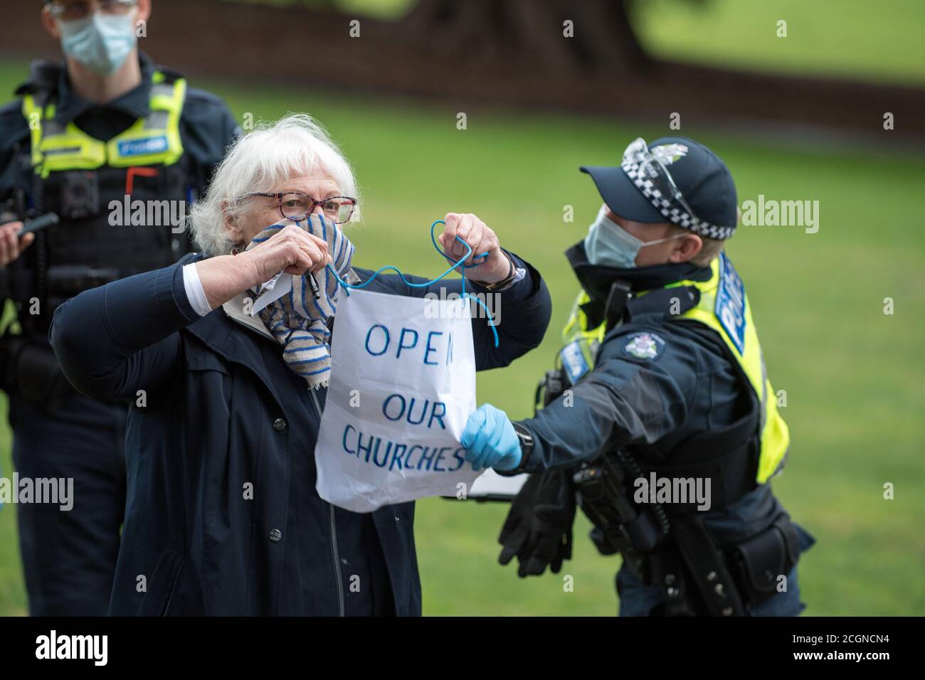 Melbourne, Australien 12. September 2020, EIN Polizeibeamter reißt ein Protestschild von einer älteren Protestierenden-Frau in Fitzroy Gardens, die versuchte, an einem Anti-Maske- und Anti-Lockdown-Protest im Park in Melbourne Australien teilzunehmen. Kredit: Michael Currie/Alamy Live Nachrichten Stockfoto