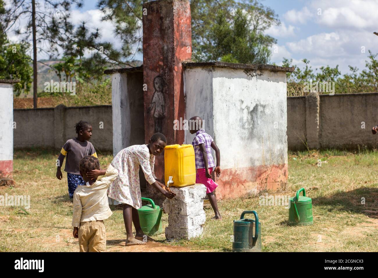 Schüler waschen sich die Hände auf dem Weg zur Latrine Stockfoto