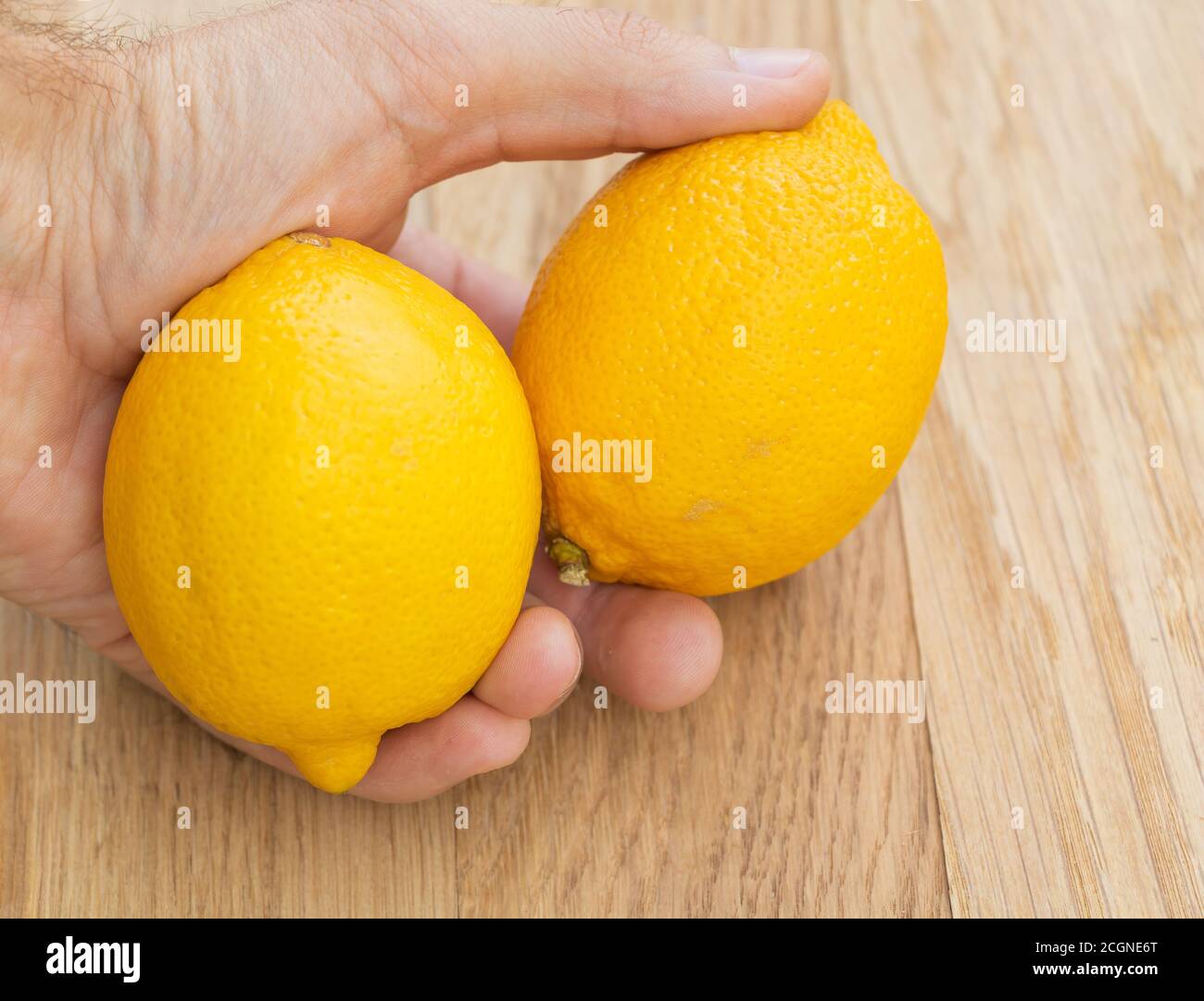 Zwei frische Zitronen in der Hand eines Mannes. Die Vorteile von Zitrone Stockfoto