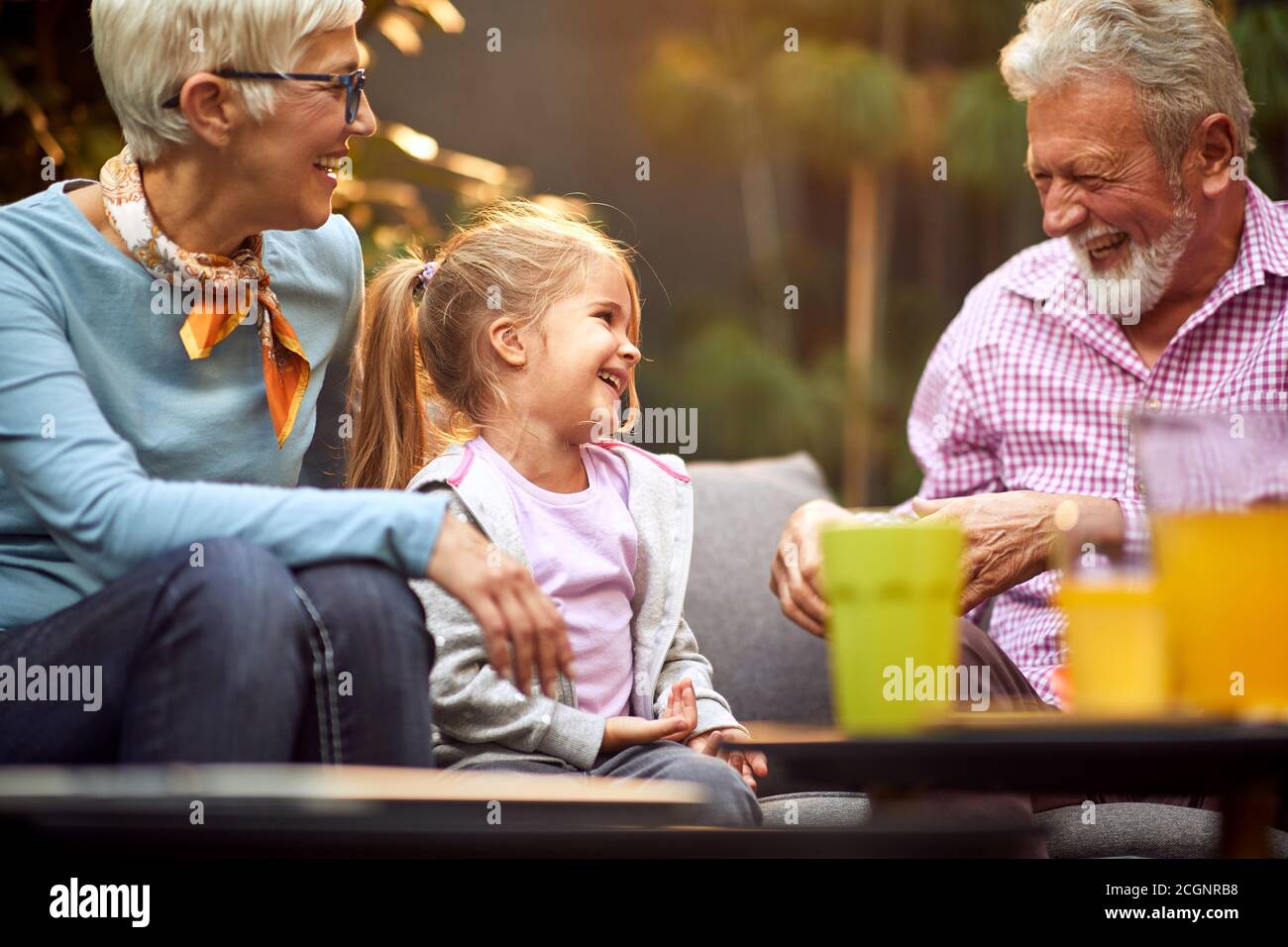 Großvater amüsant seine Enkelin, lachend, genießend, mit Oma Stockfoto