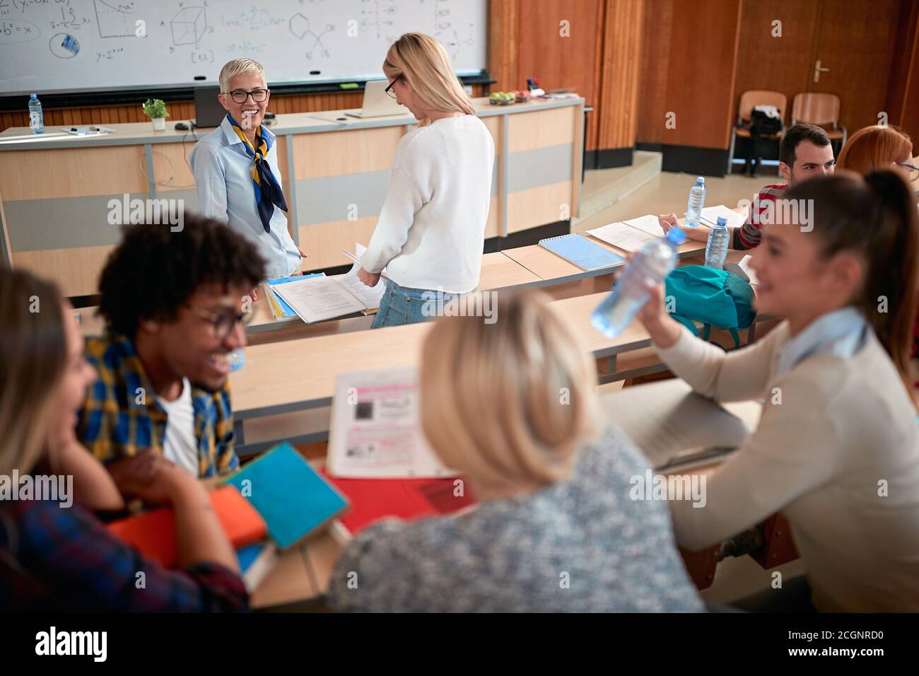 Studenten im Amphitheater in einem entspannten Gespräch über einen Vortrag Stockfoto