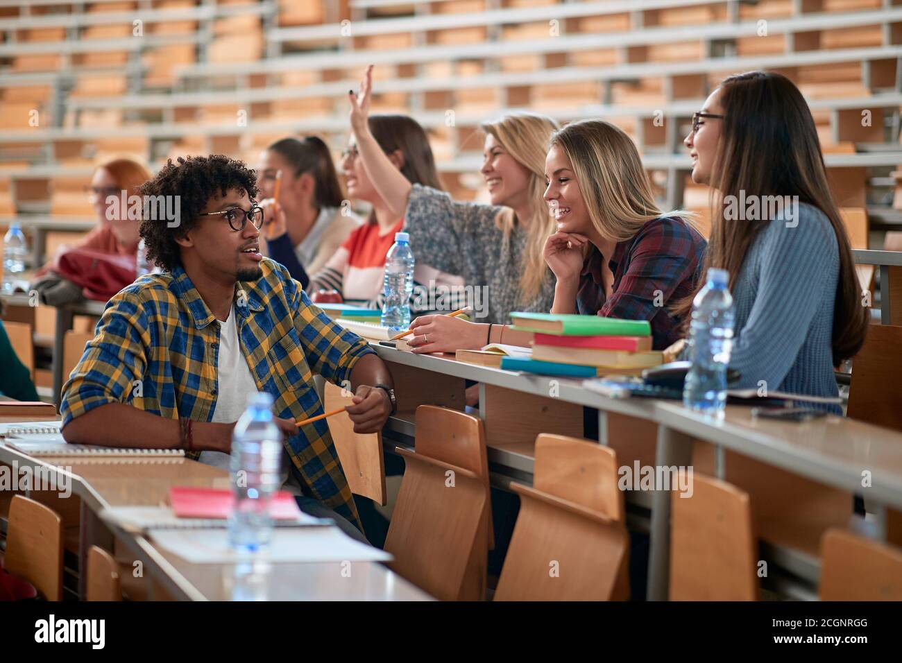 Studenten in einem entspannten Gespräch in einem Amphitheater in einem Pause eines Vortrags Stockfoto
