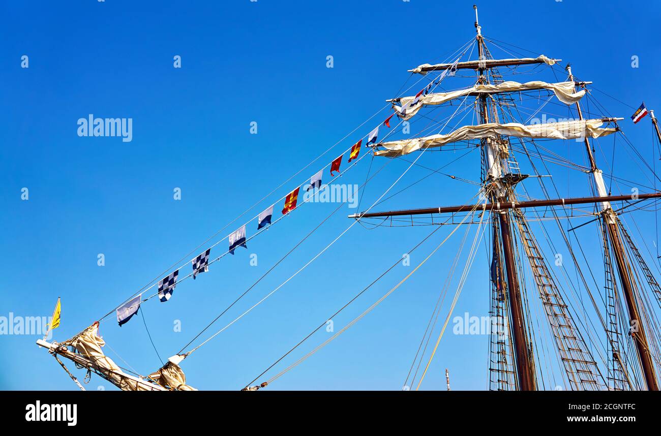 Internationale maritime Signalfahnen auf einem Fahnenmast auf einem Segelschiff mit einem blauen Himmel im Hintergrund. Stockfoto