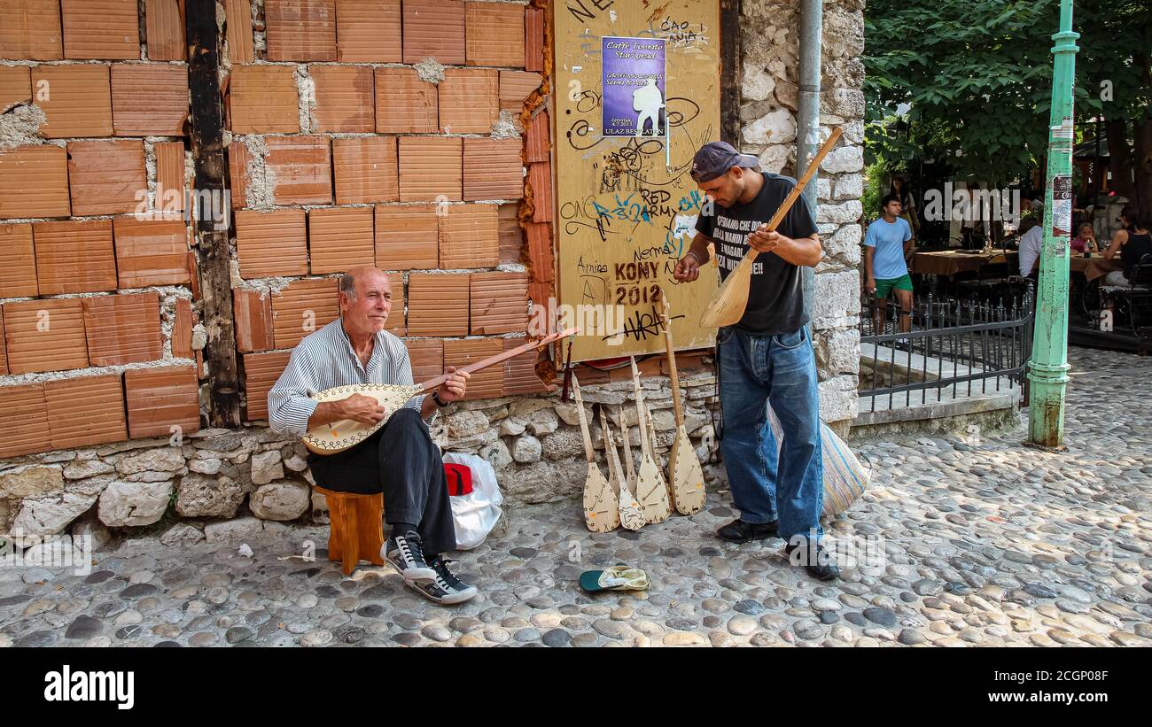 Mostar, Bosnien und Herzegowina - 4. Juli 2018: Zwei Busfahrer auf der Straße in Mostar spielen die Sargija, ein traditionelles balkan-Musikinstrument, Bosn Stockfoto