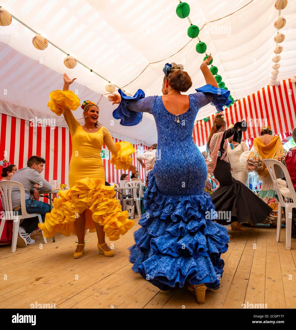 Frauen tanzen Sevillano, Spanierin mit Flamenco-Kleidern in bunten Festzelt, Casetas, Feria de Abril, Sevilla, Andalusien, Spanien Stockfoto