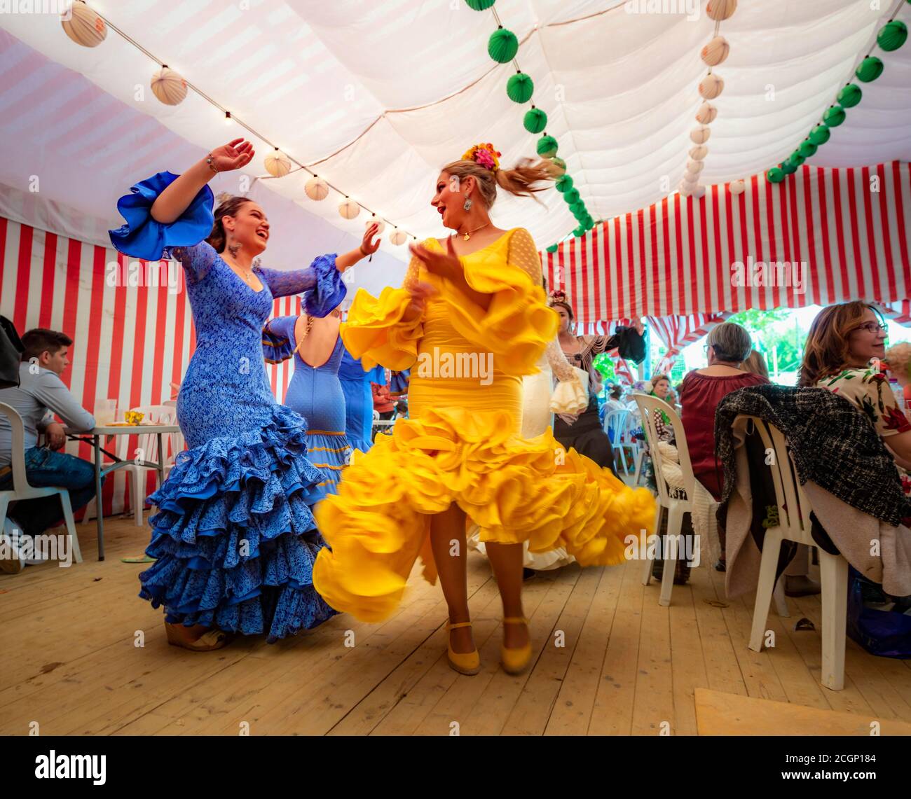 Frauen tanzen Sevillano, Spanierin mit Flamenco-Kleidern in bunten Festzelt, Casetas, Feria de Abril, Sevilla, Andalusien, Spanien Stockfoto