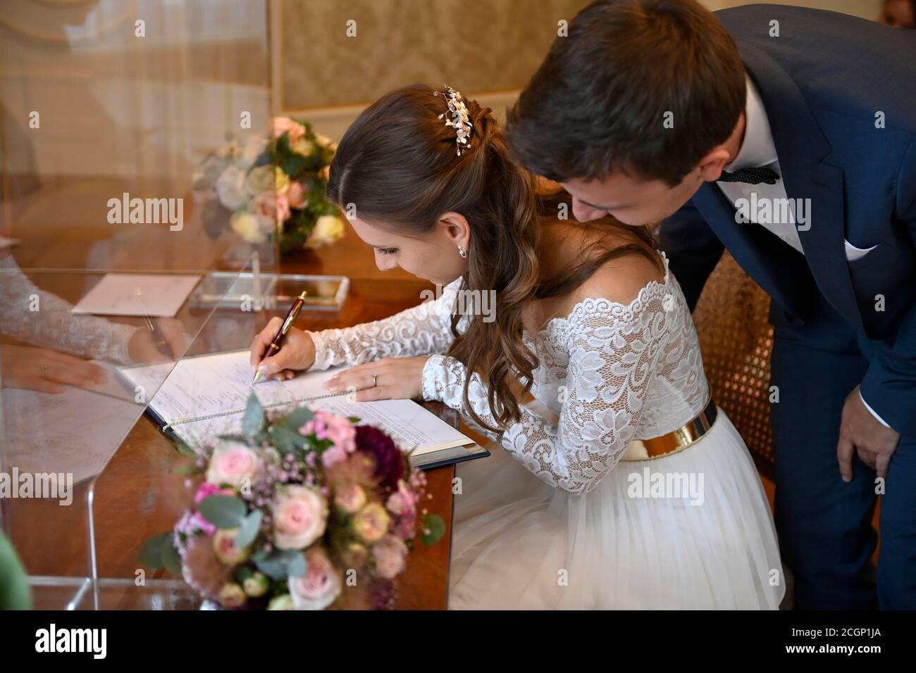 Brautpaar unterzeichnet Heiratsurkunde am Standesamt, Glasfassade wegen Coronakrise, Karlsruhe, Baden-Württemberg, Deutschland Stockfoto