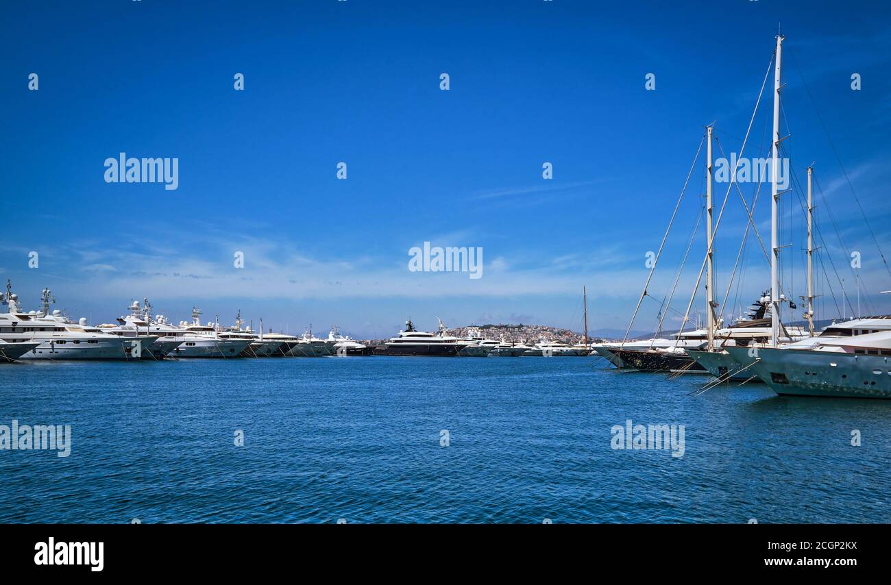 Boote und Yachten ankerten oder legten an einem hellen Sommertag in einem Yachthafen und an seiner Promenade fest. Wunderschöne Meereslandschaft. Freizeit, Kreuzfahrt, Urlaub. Stockfoto