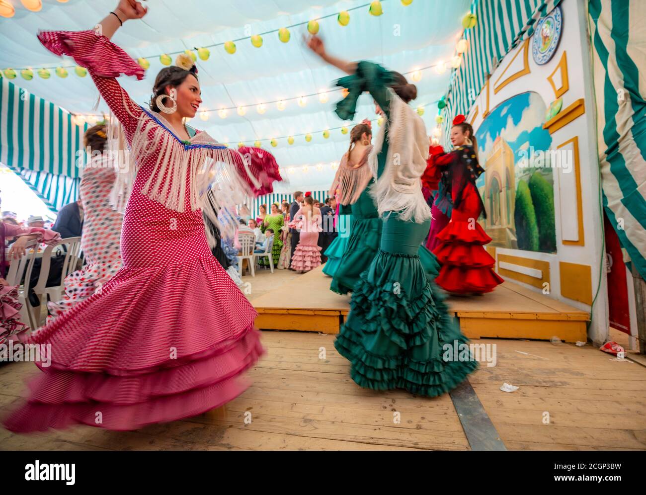 Junge Frau, die Sevillano tanzt, Spanierin mit Flamenco-Kleidern im bunten Festzelt, Casetas, Feria de Abril, Sevilla, Andalusien, Spanien Stockfoto