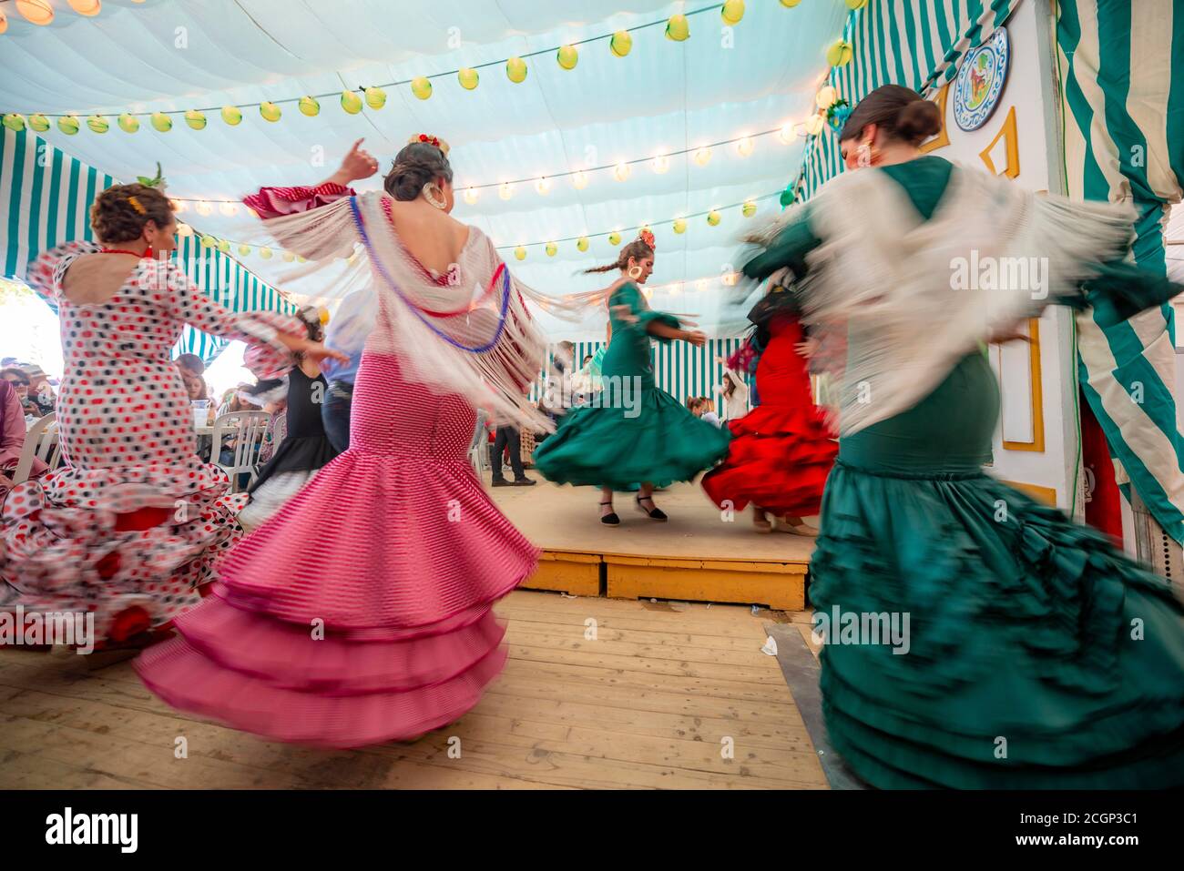 Junge Frau, die Sevillano tanzt, Spanierin mit Flamenco-Kleidern im bunten Festzelt, Casetas, Feria de Abril, Sevilla, Andalusien, Spanien Stockfoto