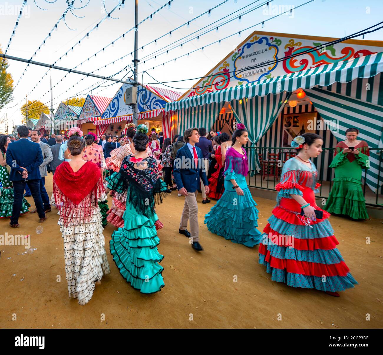 Frauen in bunten Flamenco-Kleidern, vor Festzelten, Casetas, geschmückte Straße, Feria de Abril, Sevilla, Andalusien, Spanien Stockfoto