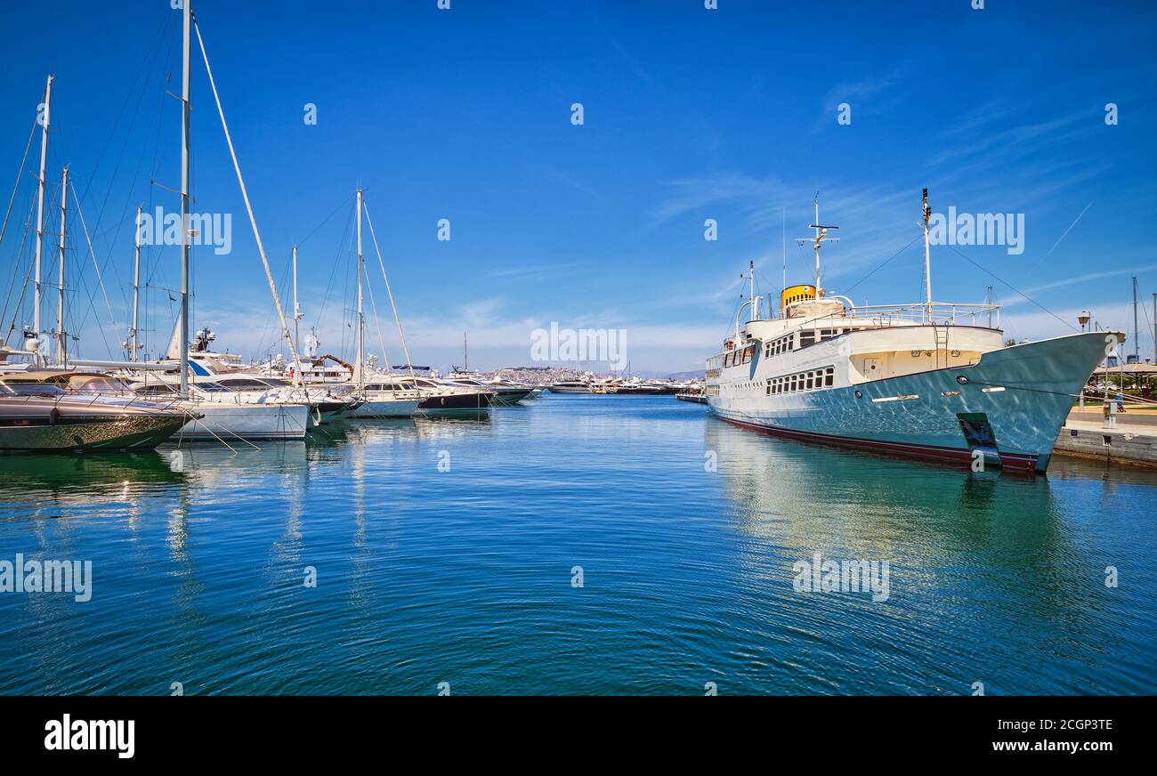Boote und Yachten ankerten oder legten an einem hellen Sommertag in der Athener Marina und an der Promenade in Glyfada fest. Athen, Griechenland Stockfoto