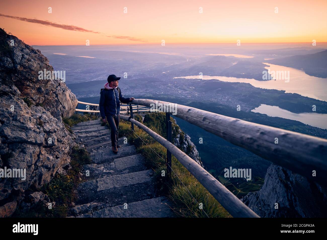 Youg Mann zu Fuß auf dem Bergwanderweg zum Pilatus gegen den Vierwaldstättersee. Landschaft bei schönem Sonnenaufgang, Schweiz. Stockfoto