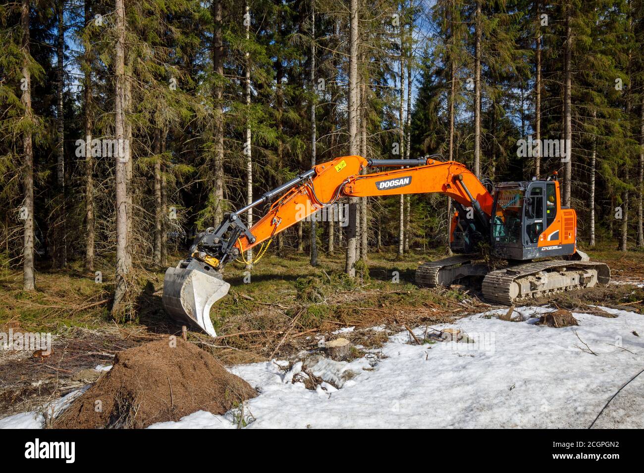 Orange Doosan DX235LCR Bagger im Wald, Finnland Stockfoto
