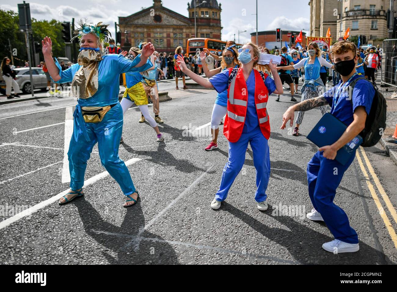 Die Menschen sind Krankenhaus Scrubs tanzen, während sie durch Bristol City Centre Parade, während Märsche und Kundgebungen bilden sich im ganzen Land fordern eine 15% Gehaltserhöhung für NHS-Arbeitnehmer und eine Erhöhung der NHS-Finanzierung. Stockfoto