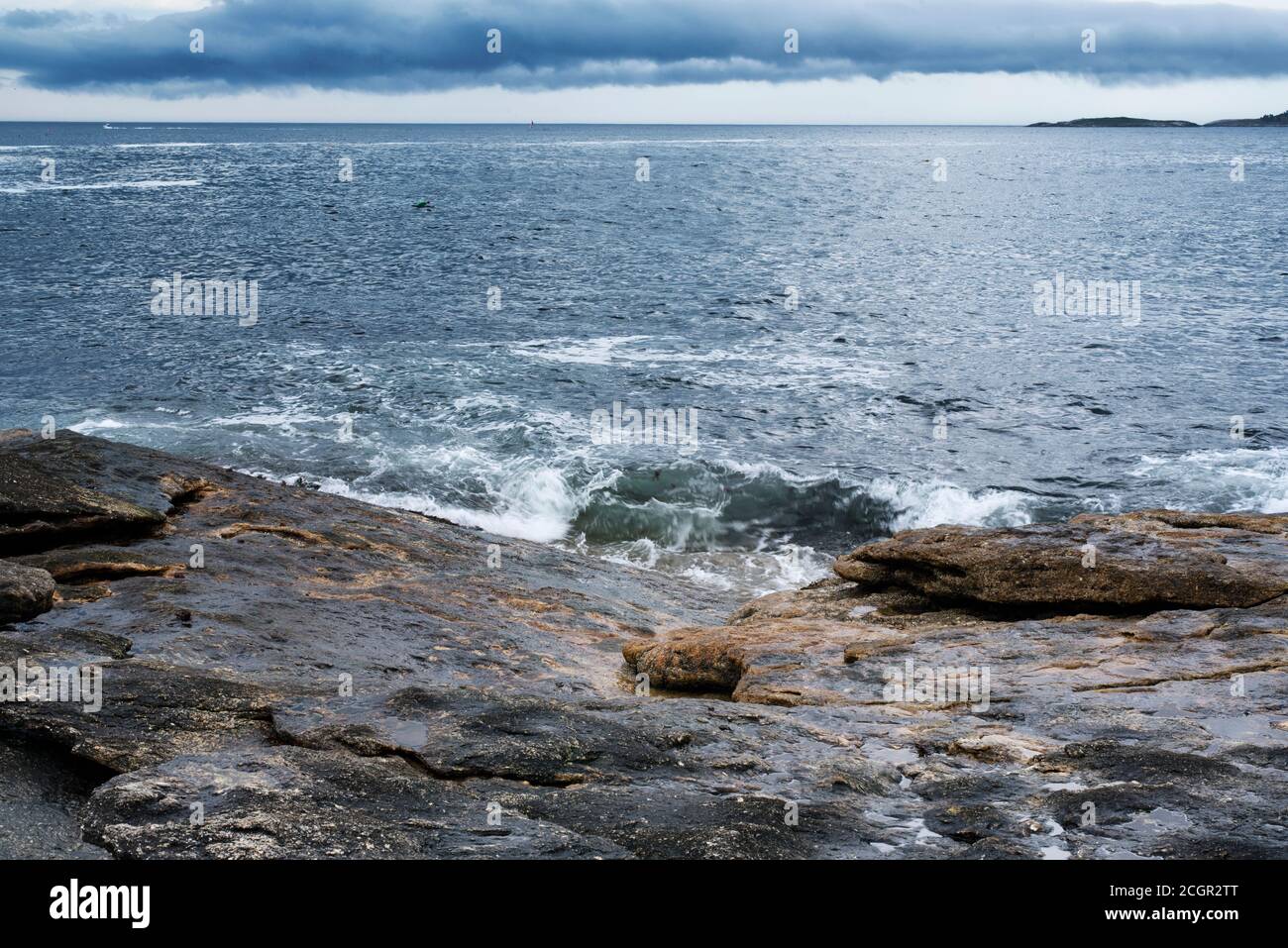 Die felsige Küste von Maine unter einem stürmischen dramatischen Himmel in Bristol Maine. Stockfoto