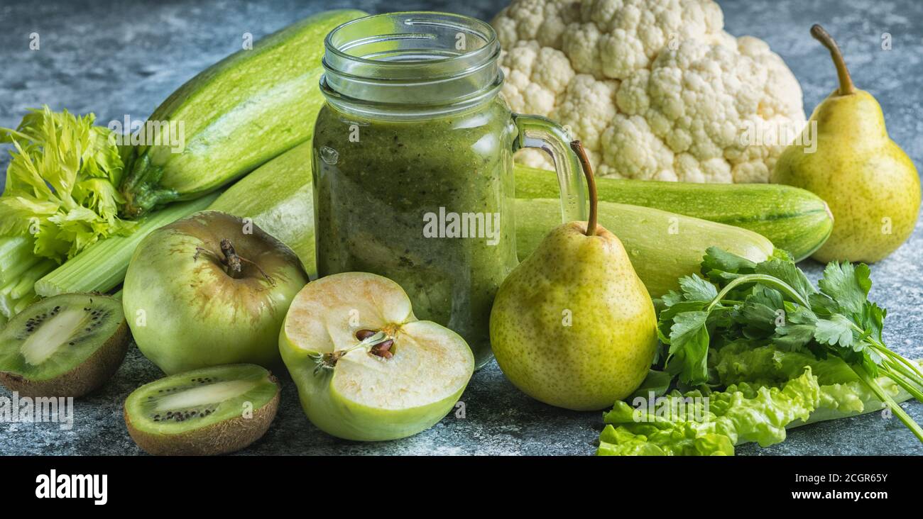 Grüner gesunder Smoothie aus grünem Gemüse und Obst auf grauem ...