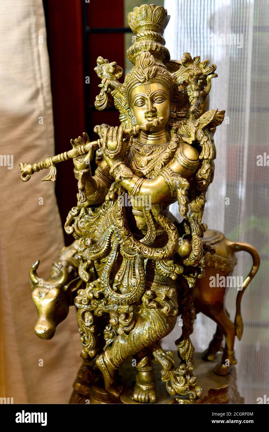 Eine feine detaillierte Messing handgemachte Statue von Lord Krishna mit Flöte und Kuh. Stockfoto