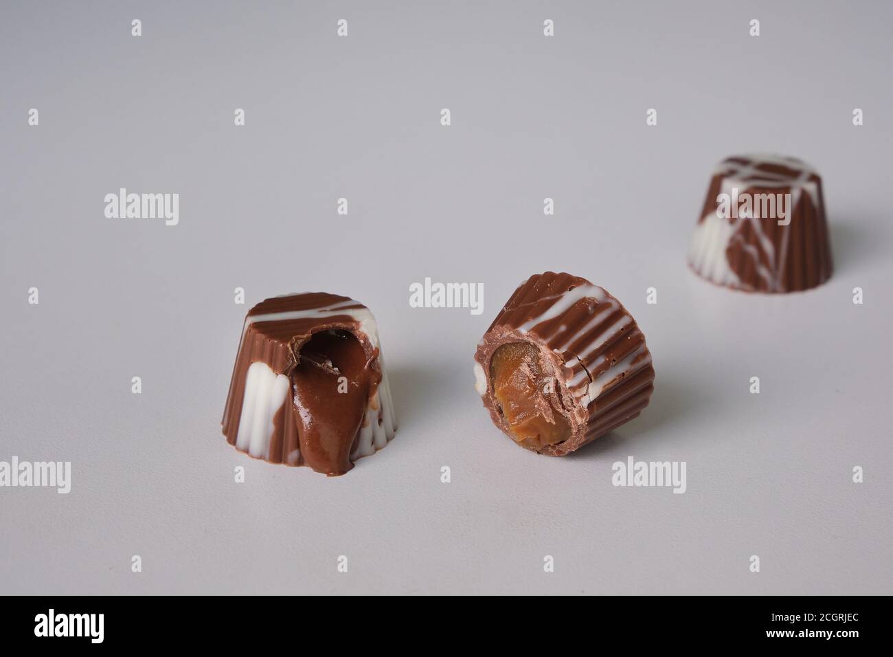 Dunkle Schokolade, Milchschokolade und weiße Schokoladenbonbons. Gefüllt mit Erdnussbutter, Dulce de leche, Kondensmilch und Haselnusscreme Stockfoto