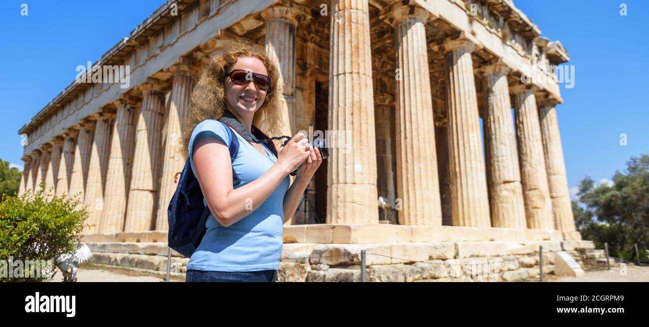 Weibliche Touristen Besuche Tempel von Hephaestus, Athen, Griechenland. Es ist berühmtes Wahrzeichen von Athen. Junge hübsche Frau fotografiert alten griechischen Gebäude in Stockfoto