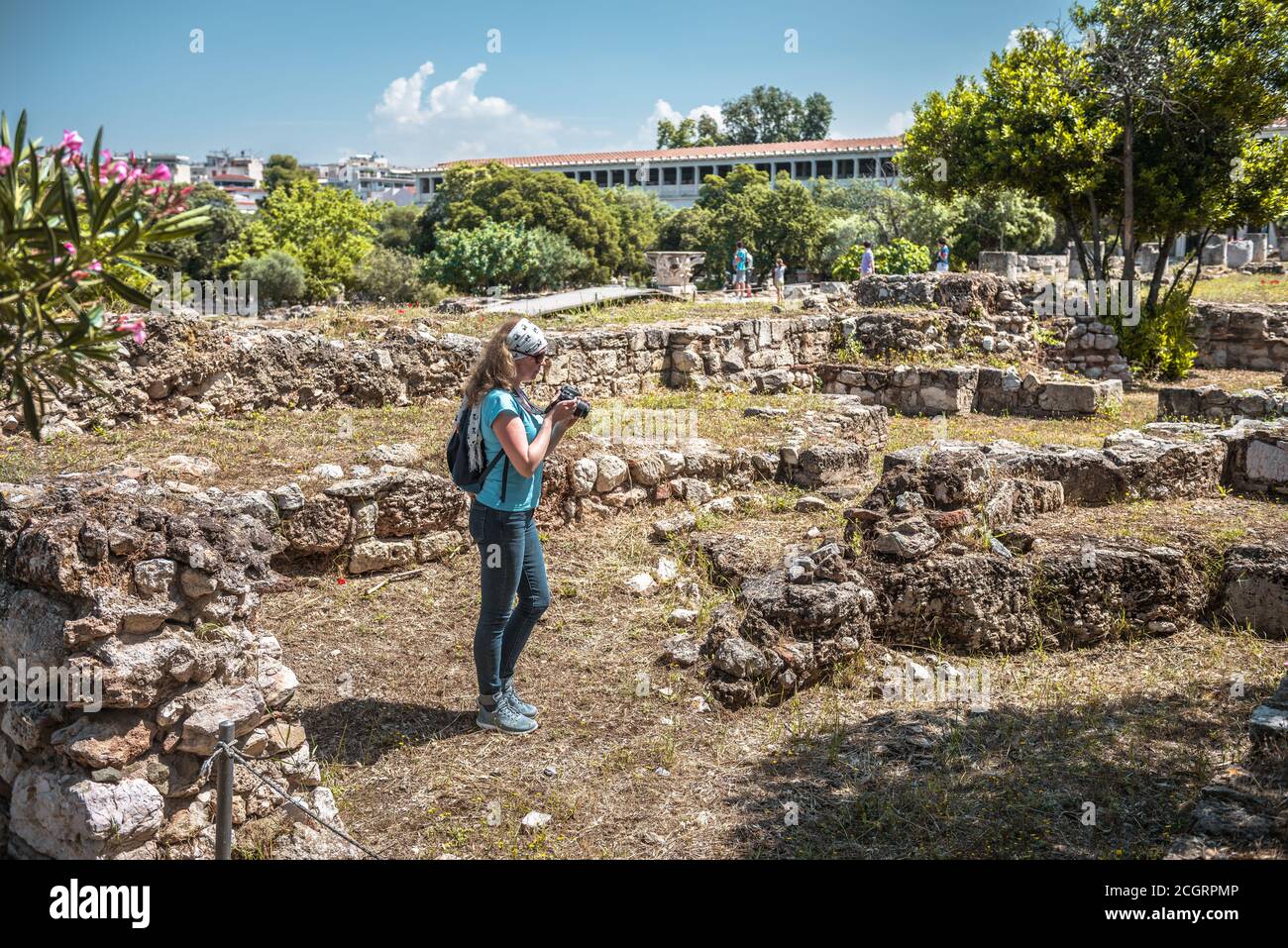Weibliche Person besucht die antike Agora in Athen, Griechenland. Es ist Touristenattraktion von Athen. Junge hübsche Frau fotografiert klassische griechische Ruinen in AThe Stockfoto