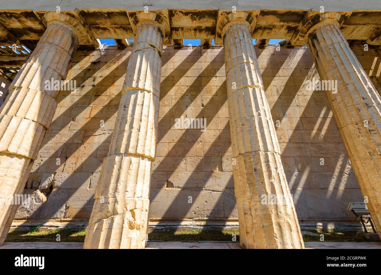 Tempel des Hephaestus im antiken Agora, Athen, Griechenland. Es ist berühmtes Wahrzeichen von Athen. Schattenstreifen an der Seitenwand des klassischen griechischen Gebäudes an der Sonne Stockfoto