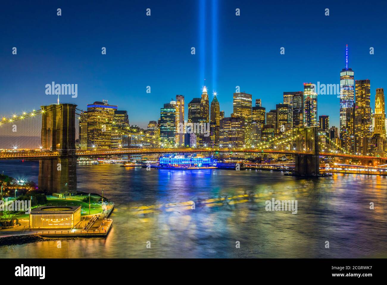 Blick auf die Skyline von Lower Manhattan und Brooklyn Brücke in der Dämmerung mit dem 11. September Tribute of Lights Glänzt über New York Stockfoto