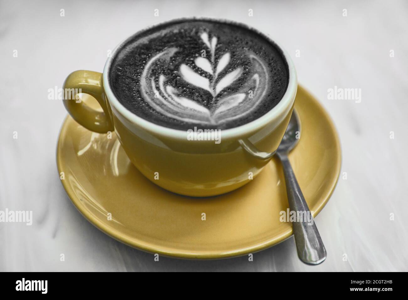 Charcoal Latte Kaffeetasse neueste Lebensmittel Trend. Aktivkohle-Pulver in Cappuccino gedünsteter Milchschaum gemischt für eine gesunde Entgiftung Kater Heilung Stockfoto