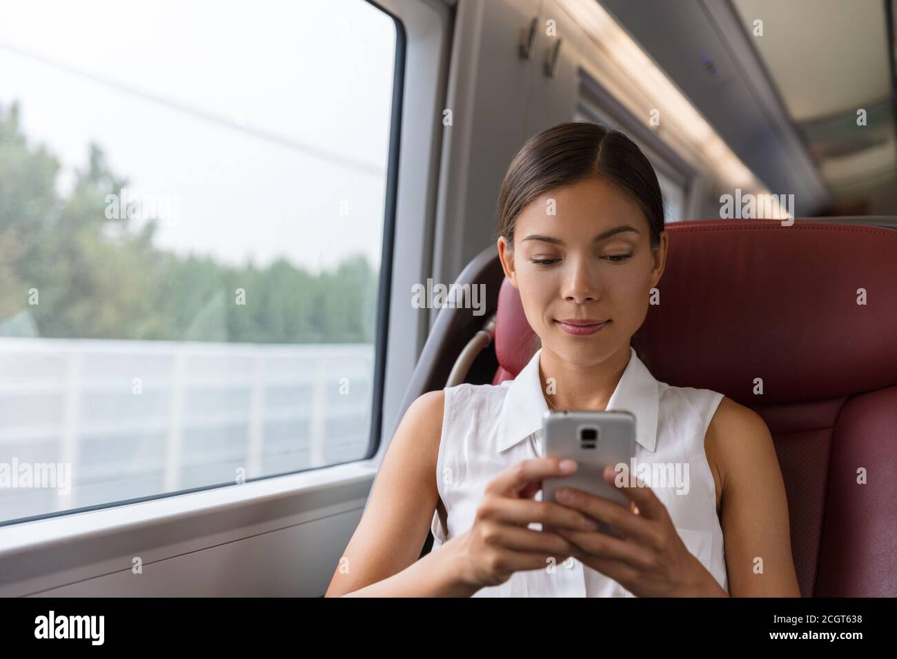 Zug pendeln First Class Frau mit Telefon SMS auf Handy-App Arbeit auf Online-WLAN-Gerät. Asiatische Geschäftsfrau Pendler professionell Stockfoto