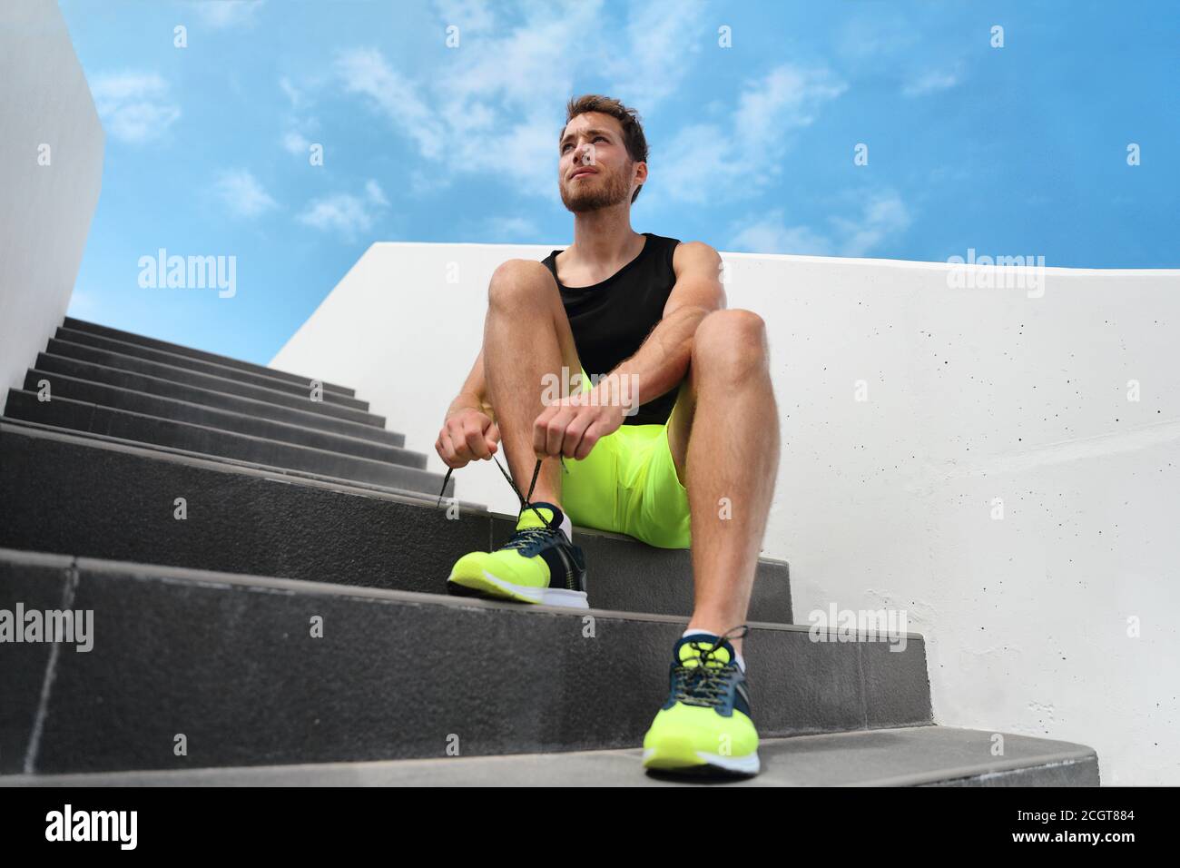Läufer Mann immer bereit, im Freien auf der Stadt Treppen Fitnessraum außerhalb binden Laufschuhe Schnürsenkel Training Cardio-Training Übung auf der Treppe trainieren. Acitve Stockfoto
